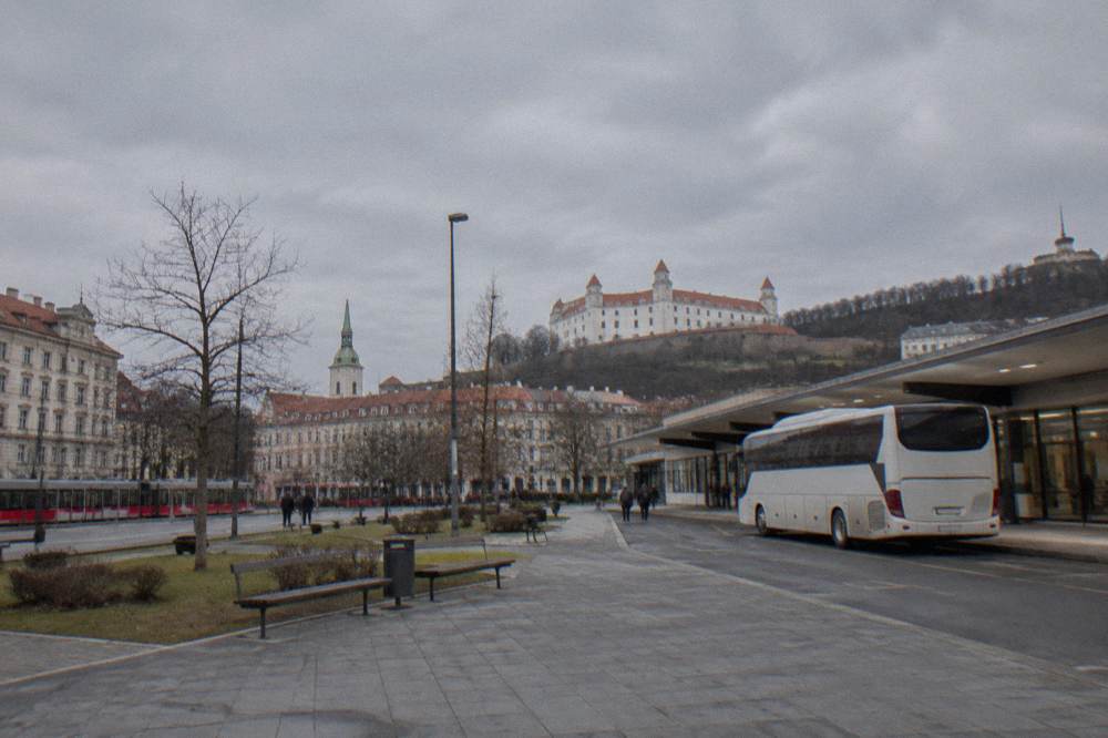 An airport bus parked outside a small terminal building in daylight
