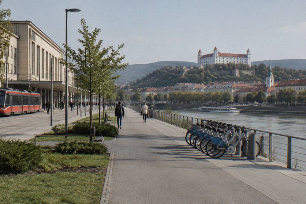 A row of shared bicycles docked beside a riverside path
