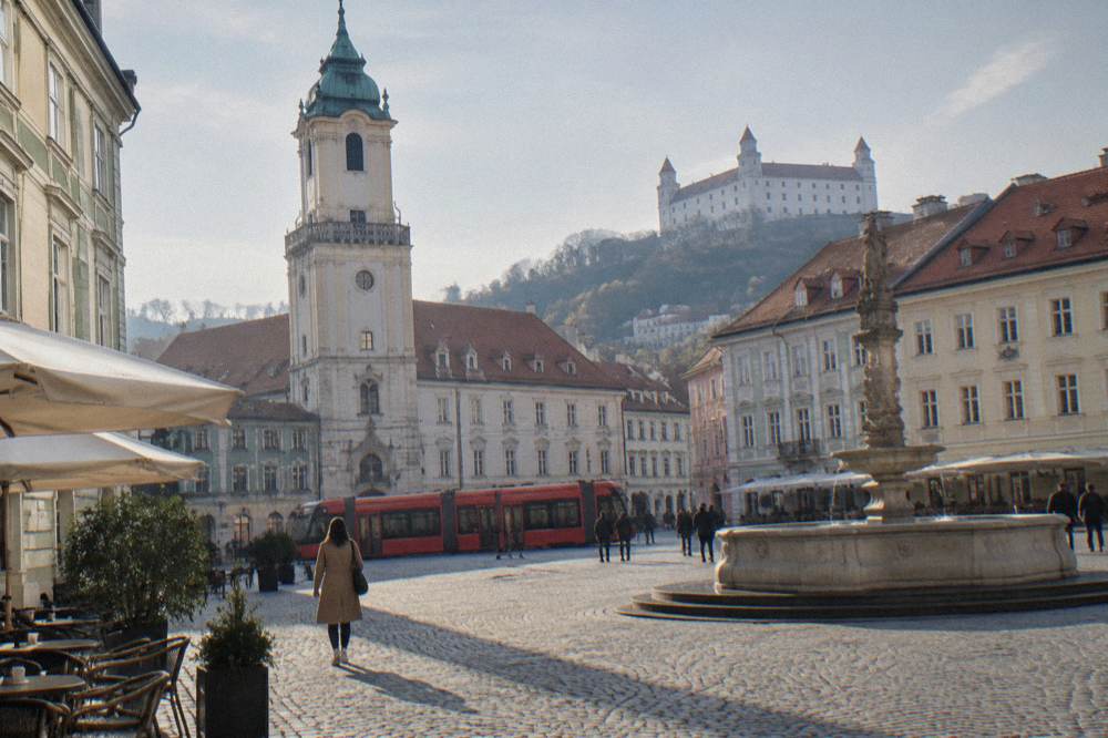 Red tram moving along a street in central Bratislava