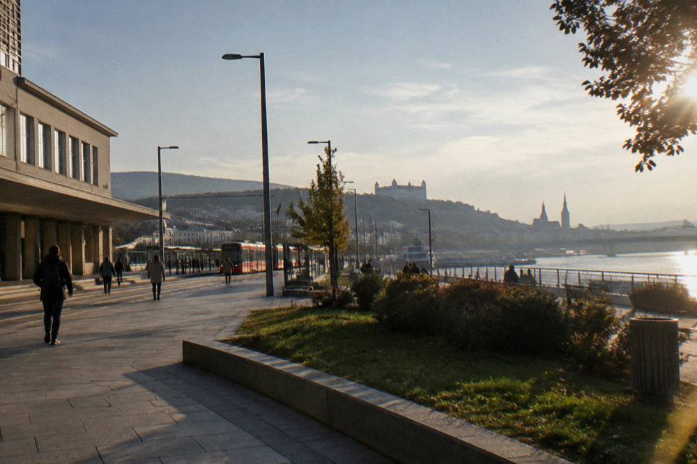A view along the Danube river toward a city skyline with church spires in the distance