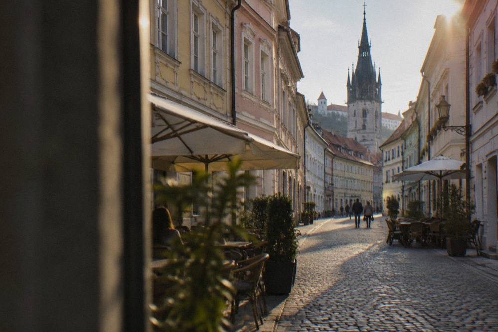 A quiet lane in Bratislava's pedestrian Old Town with pastel facades and cafe tables