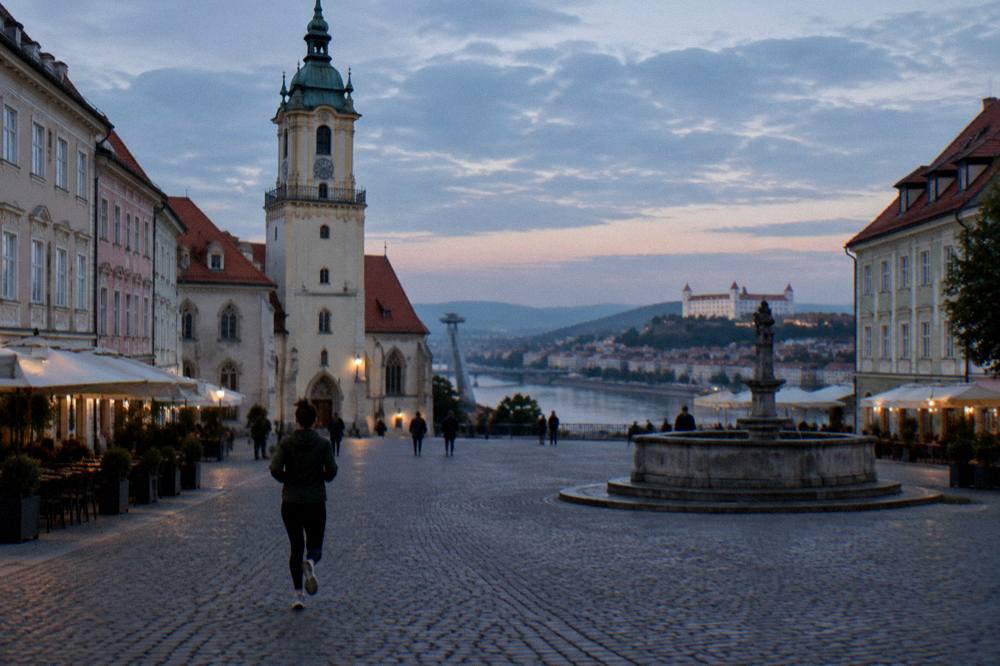 Evening light over Bratislava rooftops toward the Danube and distant hills