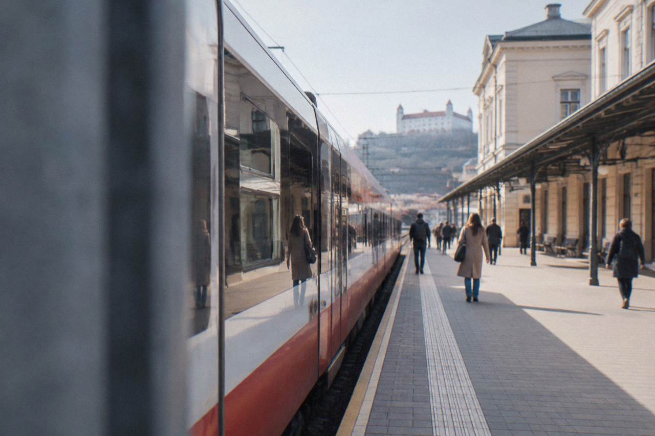 A train standing at a platform beside a station building in Bratislava
