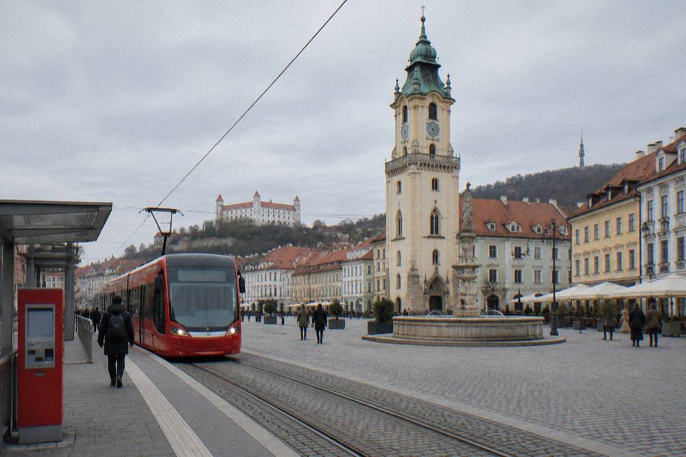 A ticket machine on a Bratislava tram platform with a tram arriving