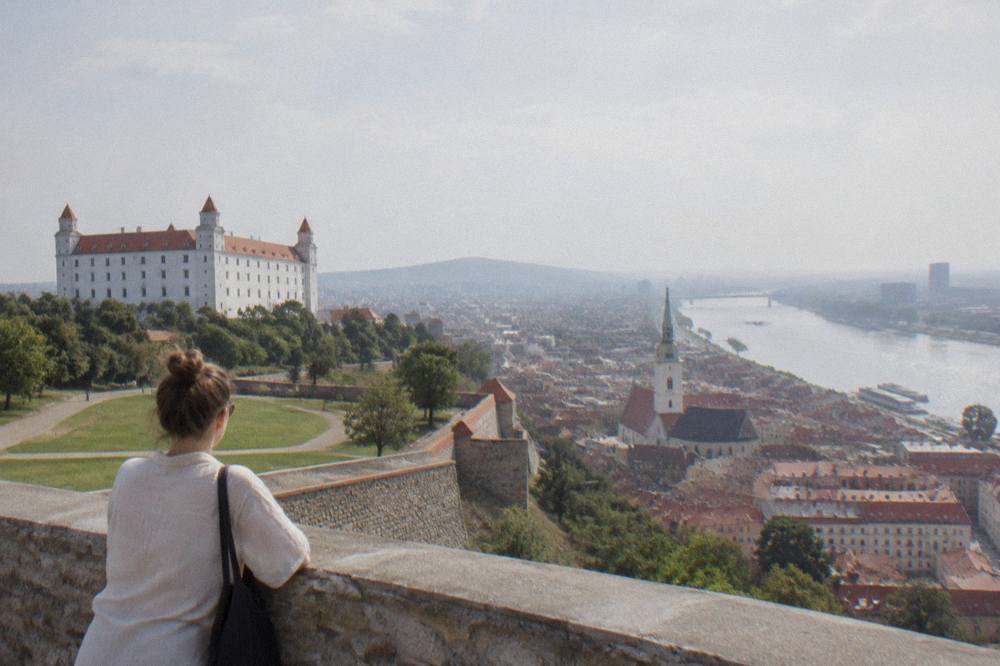 A visitor viewing the city from Bratislava Castle ramparts