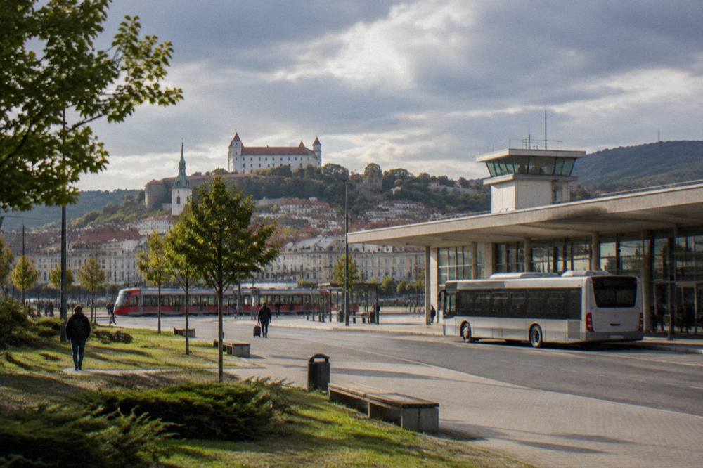 A small modern airport terminal building with a bus stopped at the kerb outside