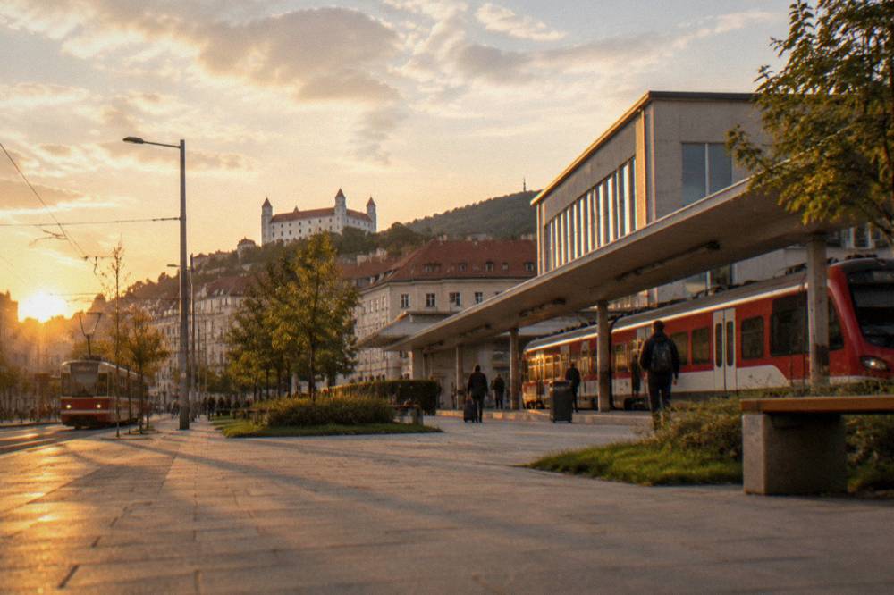 A red regional train waiting at a platform beside a modern station building