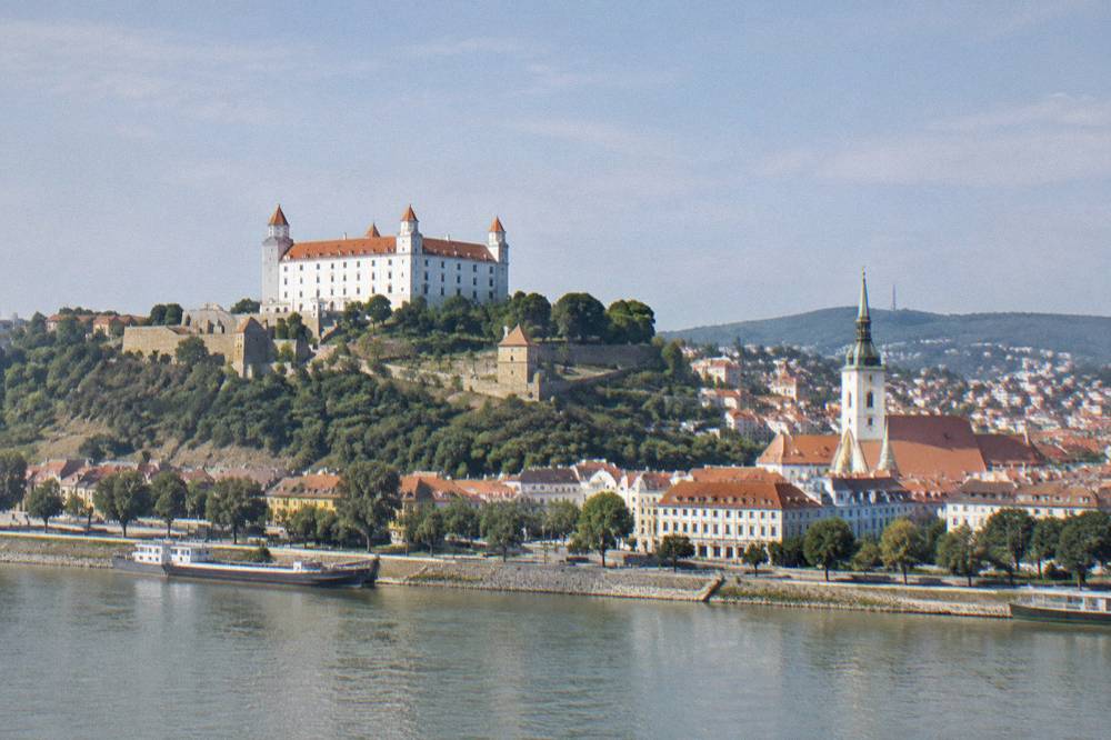 Bratislava Castle on its hill above the Danube river with the old town rooftops below