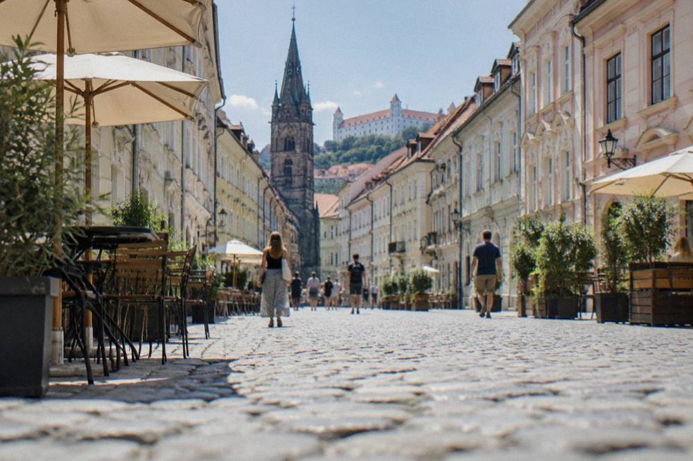 People strolling on a cobbled pedestrian street in the Old Town on a bright morning
