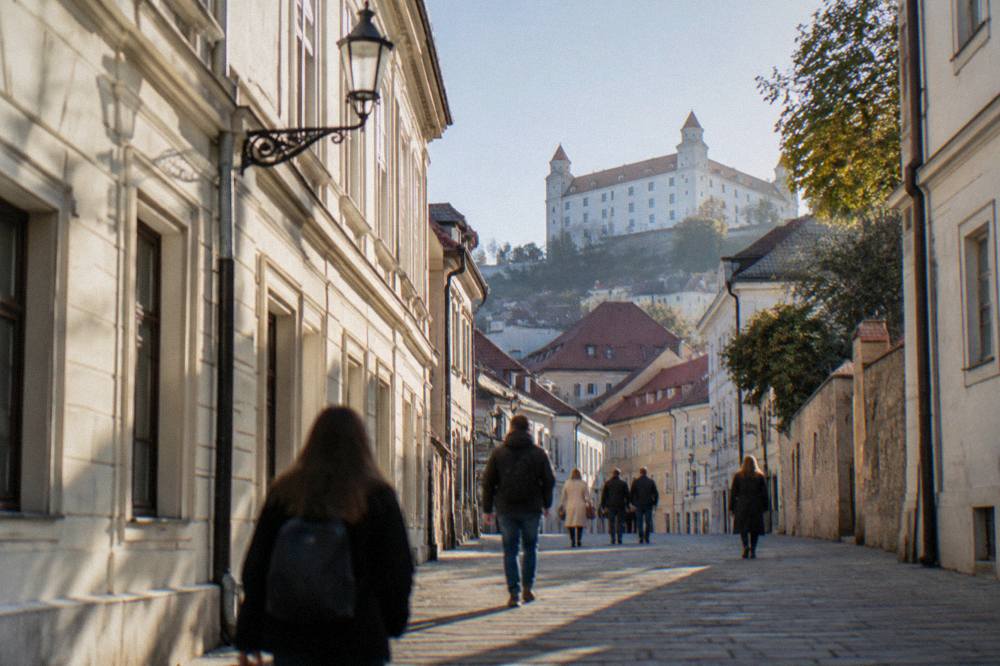 Visitors walking through a narrow pedestrian street of old townhouses