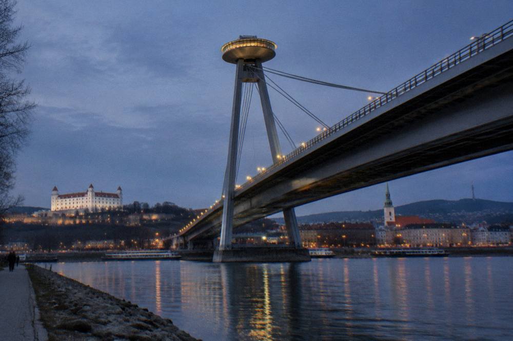 The illuminated UFO observation deck structure on the bridge above the Danube at night