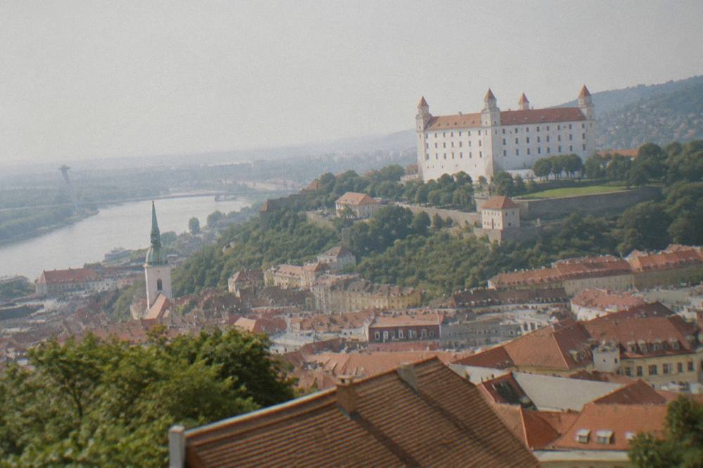 Bratislava Castle standing on its hill above red rooftops and the Danube plain