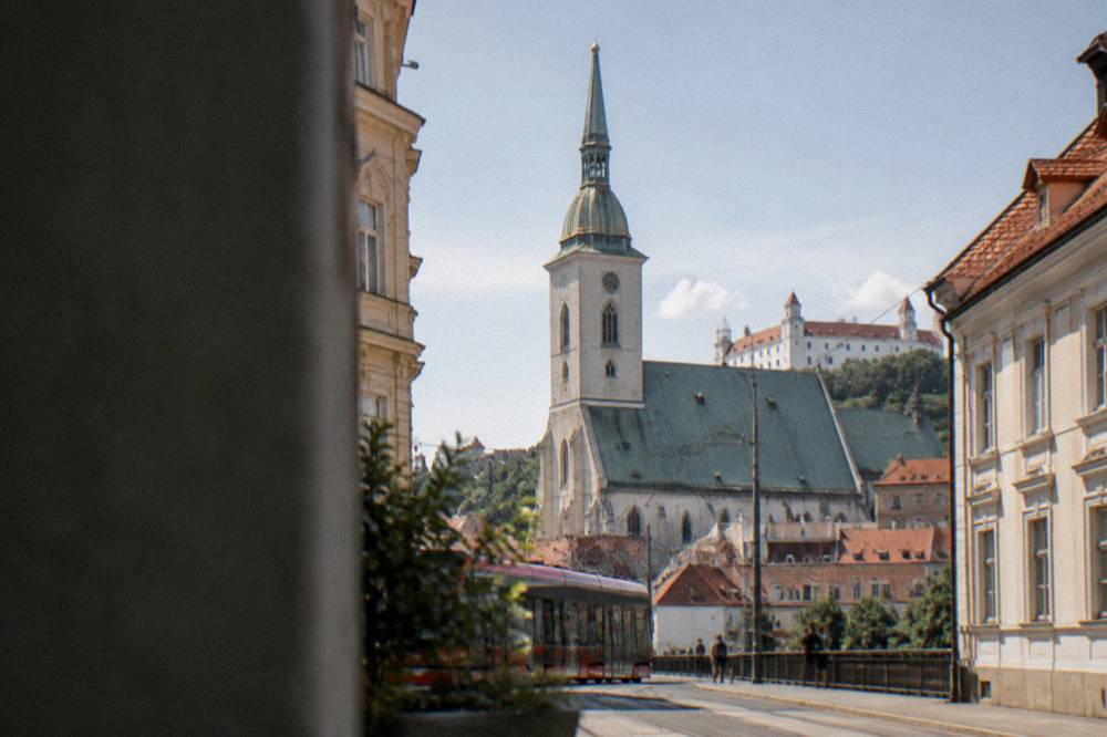The gothic tower and roof of St Martin's Cathedral seen from a Bratislava street