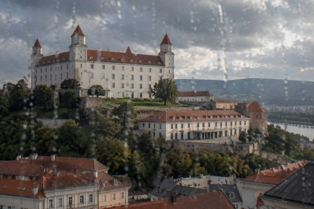 Bratislava Castle seen through rain streaks with the museum building behind the courtyard
