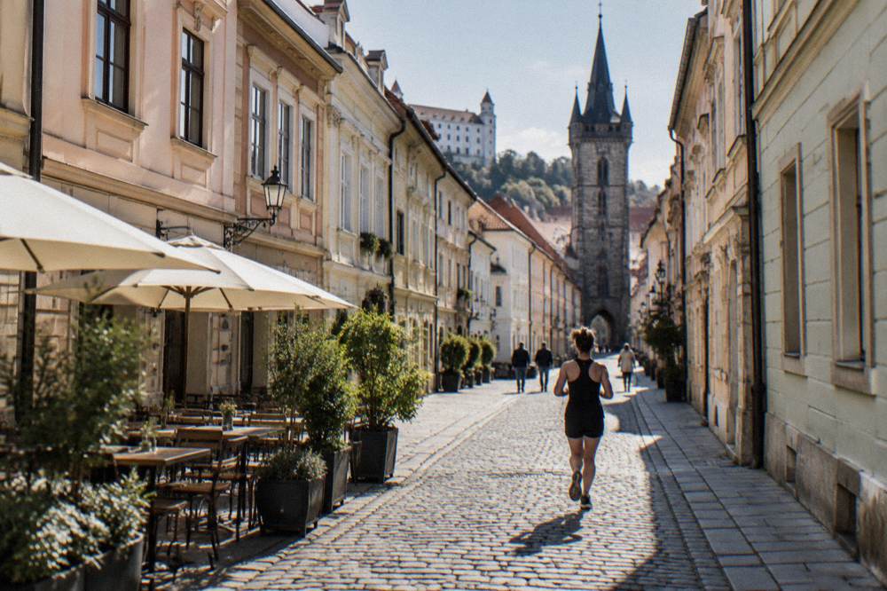 A narrow Old Town street with sunlight reaching between the building fronts