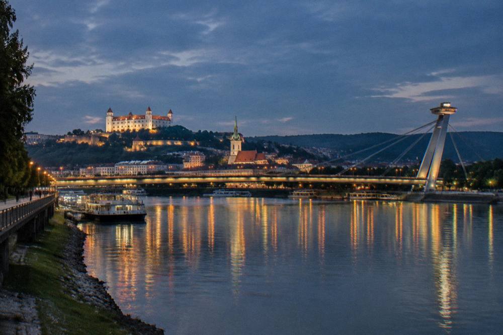 Night view of a Danube bridge lit up over the river in Bratislava