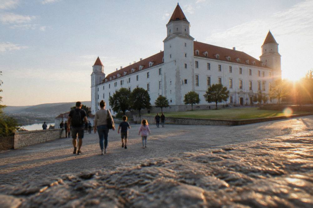 Parents and children walking on the wide paved courtyard of Bratislava Castle