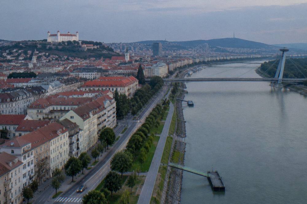 Aerial view of dense housing blocks arranged in rows beside the river