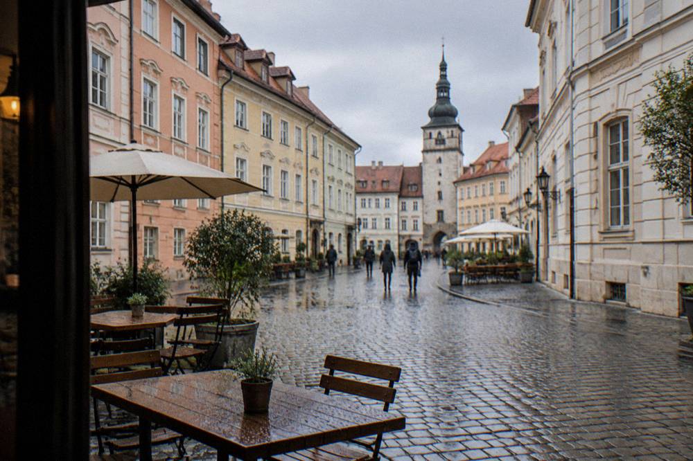 A cobbled square in Bratislava's Old Town with coloured townhouses and outdoor tables