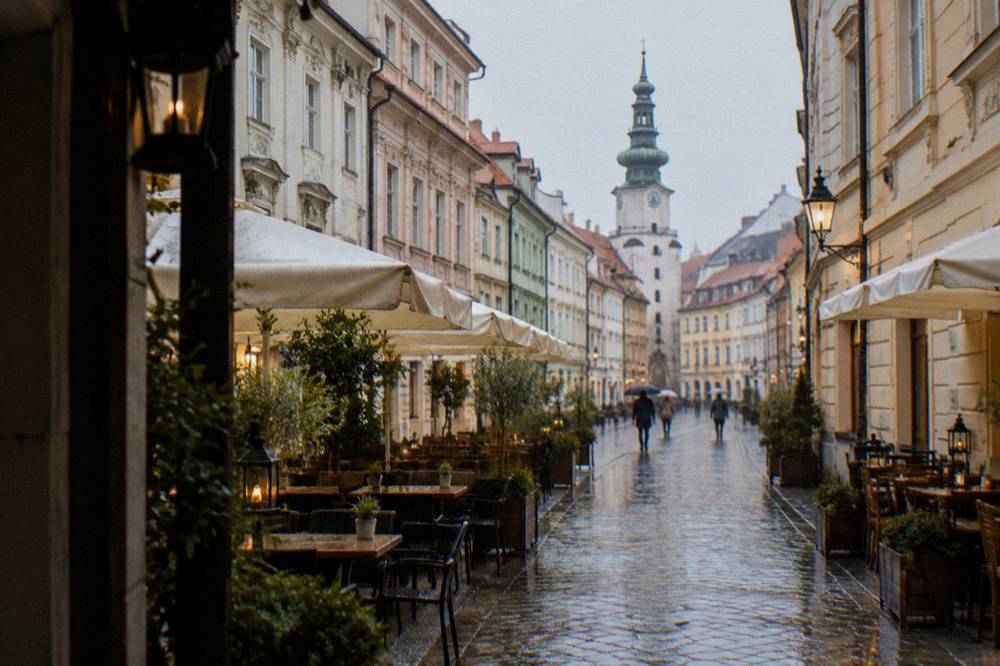 A walking street in Bratislava's Old Town lined with restaurant tables and lanterns