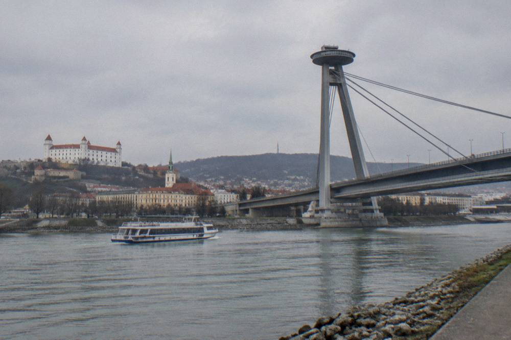 Passenger boat on the Danube approaching the Bratislava riverfront and UFO bridge