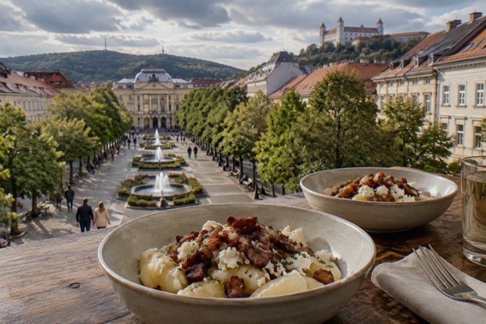 Bowls of potato dumplings with sheep cheese and fried bacon on a rustic wooden table