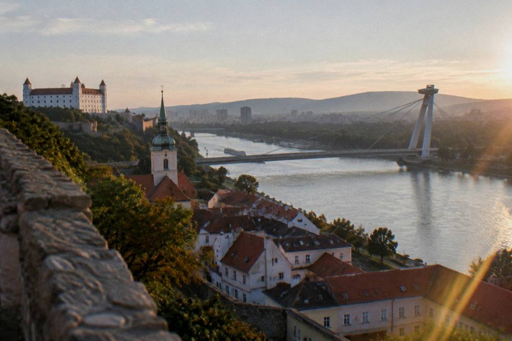 The Danube river and the UFO bridge seen from the castle hill above Bratislava at golden hour