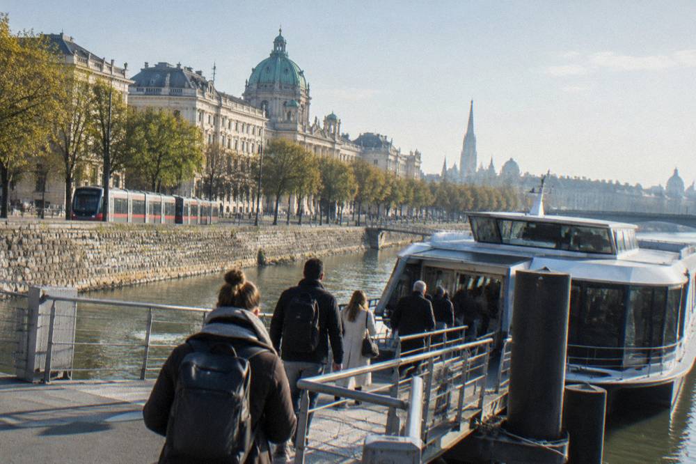 Travellers boarding a sleek river catamaran at a Danube landing stage